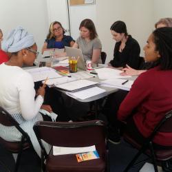 Cast members for <em>The Swallowing Dark</em> along with director Claire Moyer sit at their first table read rehearsal. 