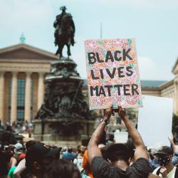 A protestor holds up a sign at a BLM protest in Philadelphia. Photo: Chris Henry via Unsplash
