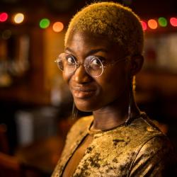 Satchel Williams, a young Black actor with cropped blonde hair, looks straight at the camera with a slight smile.